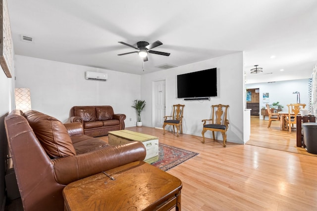 living room featuring a ceiling fan, visible vents, recessed lighting, an AC wall unit, and light wood-type flooring