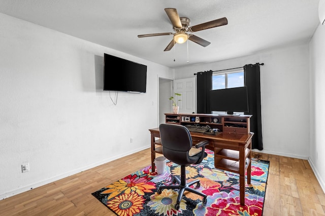 home office with baseboards, ceiling fan, and wood finished floors