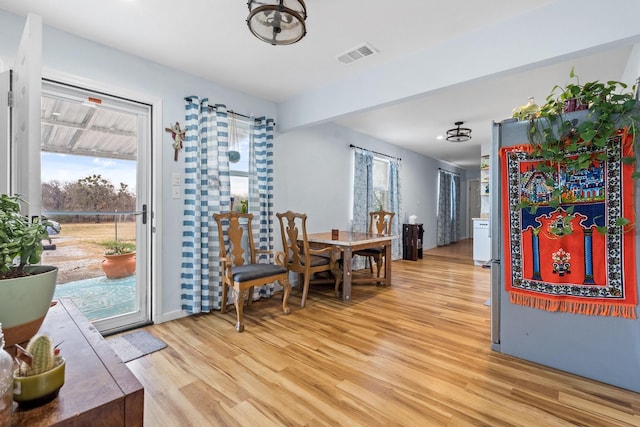 dining area with visible vents and light wood-style flooring