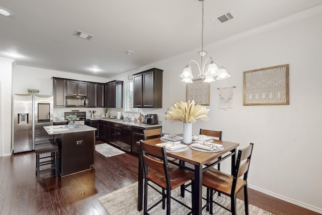 kitchen featuring dark wood-style floors, black appliances, a kitchen island, and visible vents