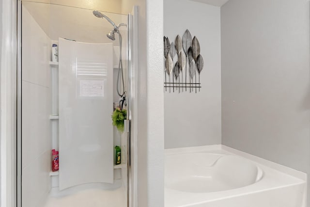 full bathroom featuring a garden tub and a shower stall