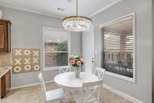 dining room with a chandelier, plenty of natural light, baseboards, and crown molding