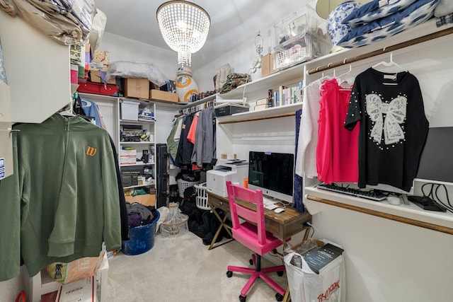 spacious closet with a chandelier and carpet