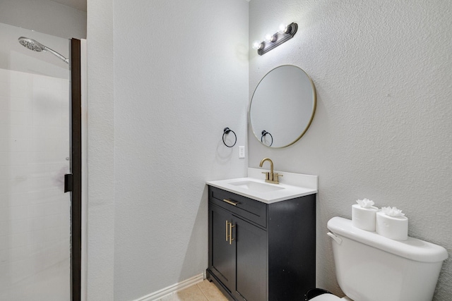 bathroom featuring tiled shower, a textured wall, vanity, and toilet