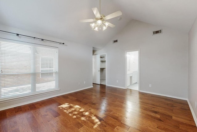 spare room with wood finished floors, visible vents, and baseboards