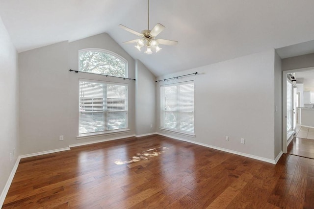 empty room featuring a ceiling fan, high vaulted ceiling, baseboards, and wood finished floors