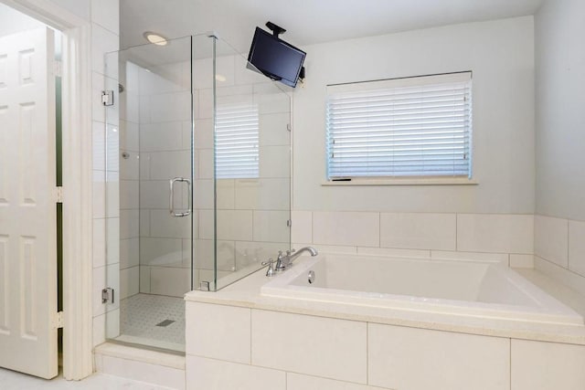 bathroom with a shower stall and a bath