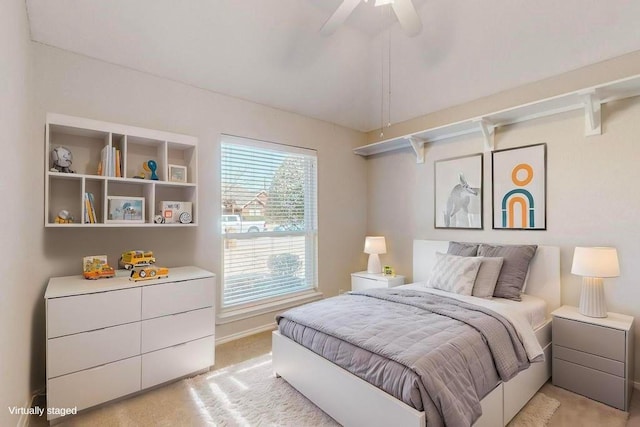 bedroom with light carpet, vaulted ceiling, and a ceiling fan