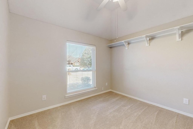 unfurnished room with light carpet, ceiling fan, vaulted ceiling, and baseboards