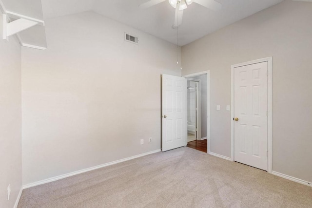 empty room featuring carpet, visible vents, vaulted ceiling, ceiling fan, and baseboards