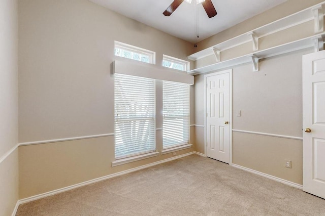 carpeted spare room featuring baseboards, a ceiling fan, and a healthy amount of sunlight