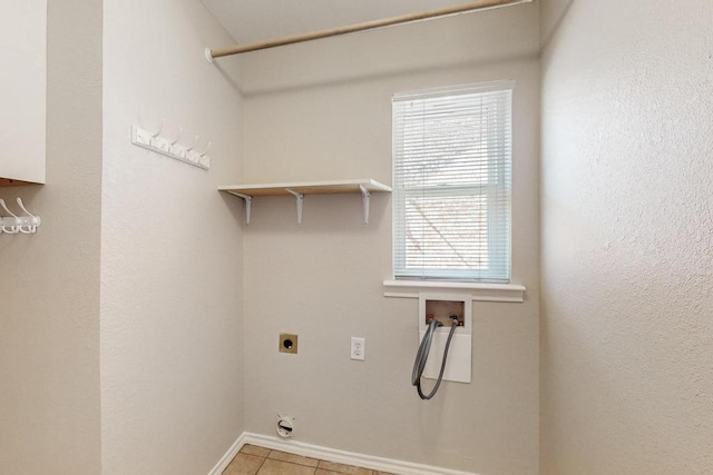 clothes washing area featuring washer hookup, electric dryer hookup, laundry area, baseboards, and tile patterned floors