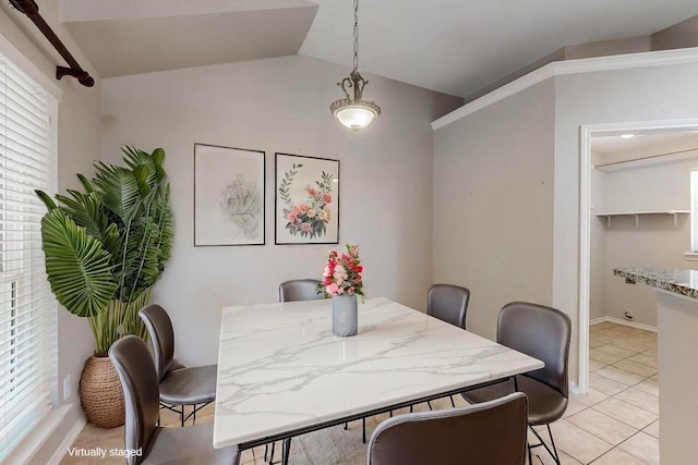 dining space featuring lofted ceiling, light tile patterned flooring, and baseboards