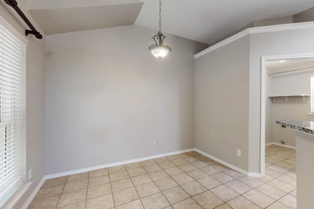 unfurnished dining area featuring lofted ceiling, light tile patterned floors, and baseboards