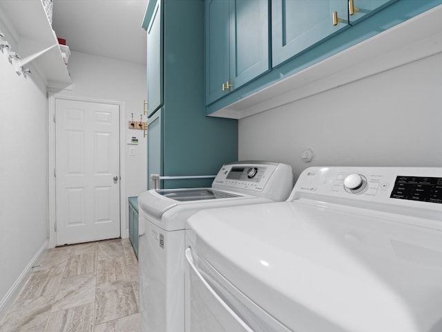 laundry room with cabinet space, baseboards, and washer and dryer