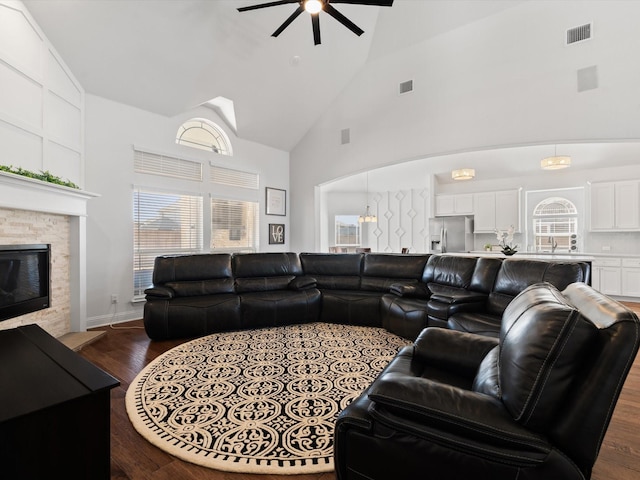 living room with plenty of natural light, visible vents, a fireplace, and wood finished floors