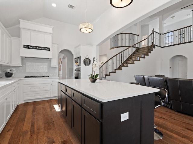 kitchen with visible vents, dark wood-type flooring, oven, and white cabinetry