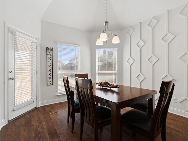 dining space featuring a chandelier, dark wood finished floors, and baseboards