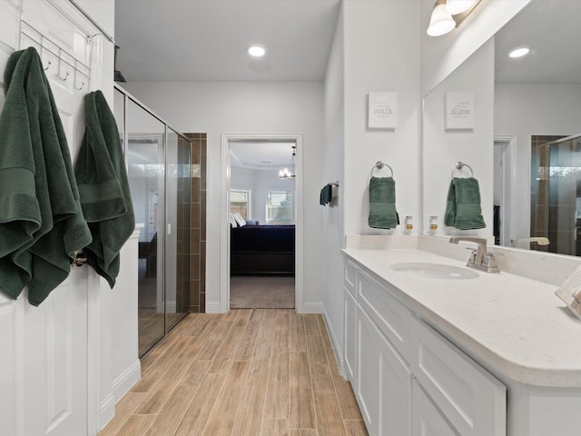 full bathroom with a stall shower, ensuite bath, wood finished floors, and vanity