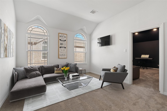 living area featuring lofted ceiling, a wealth of natural light, carpet flooring, and visible vents