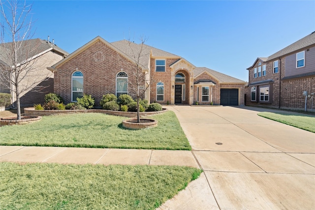 view of front facade featuring a front yard, concrete driveway, brick siding, and an attached garage