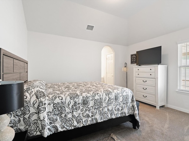 bedroom with arched walkways, visible vents, carpet flooring, vaulted ceiling, and baseboards