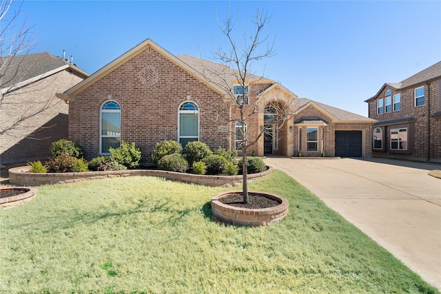 view of front of home with a garage, a front yard, brick siding, and driveway