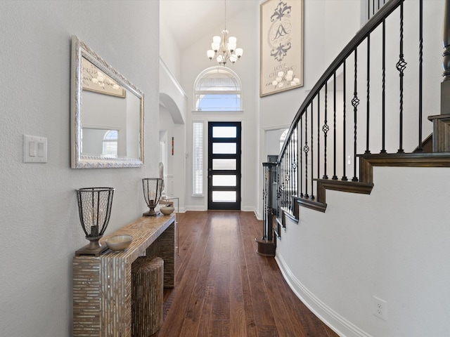 entryway with baseboards, wood-type flooring, stairs, high vaulted ceiling, and a notable chandelier