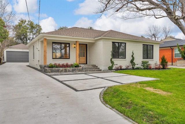 view of front of home featuring brick siding, a detached garage, crawl space, an outdoor structure, and a front lawn