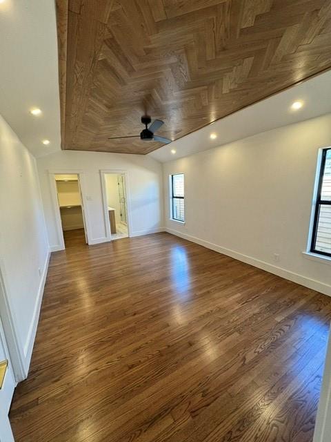 empty room featuring baseboards, dark wood finished floors, lofted ceiling, ceiling fan, and recessed lighting