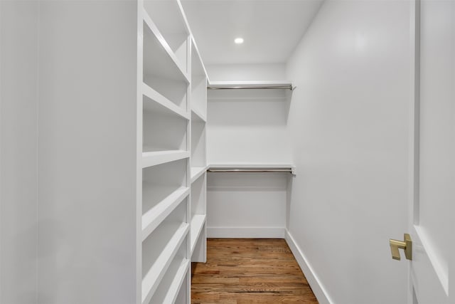 walk in closet with wood finished floors