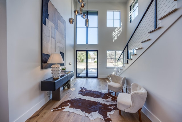 entryway with stairway, baseboards, and wood finished floors