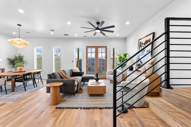 living area featuring french doors, stairway, wood finished floors, and recessed lighting