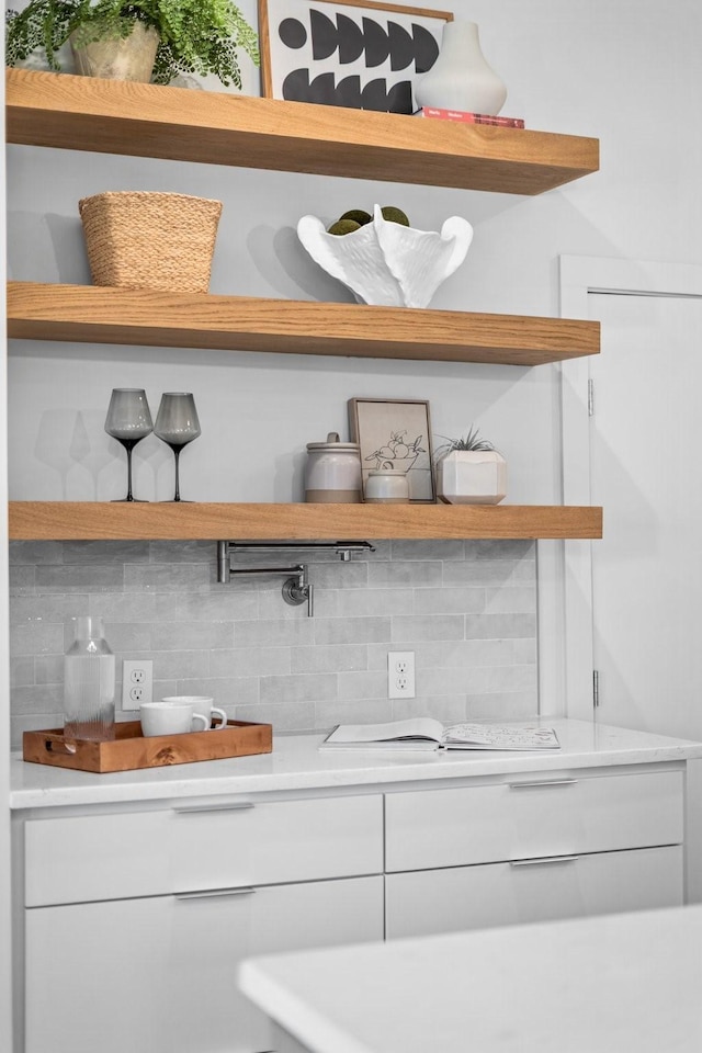 interior space with white cabinets, tasteful backsplash, open shelves, and light countertops