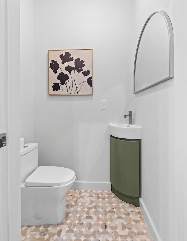 bathroom with baseboards, vanity, and toilet