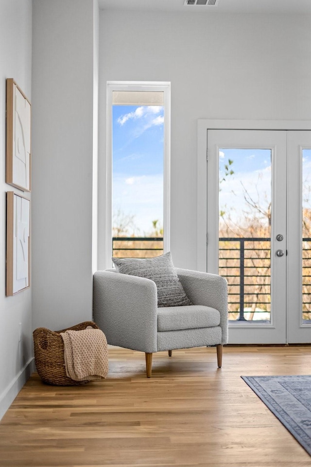 living area with a wealth of natural light, french doors, and wood finished floors