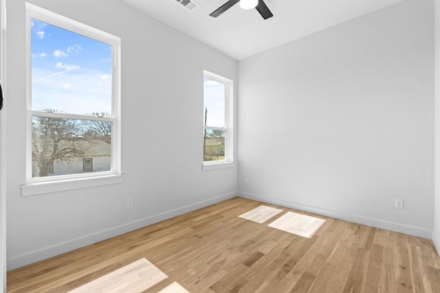 empty room with ceiling fan, baseboards, and wood finished floors