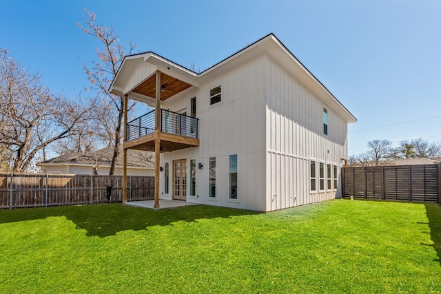 rear view of property with a fenced backyard, a yard, a balcony, and ceiling fan