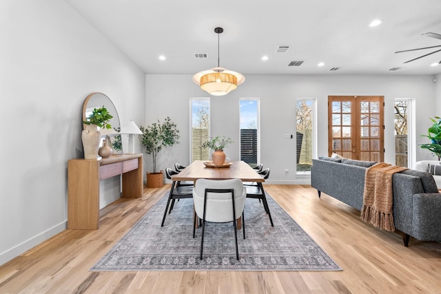 dining area with light wood-style flooring, visible vents, and french doors