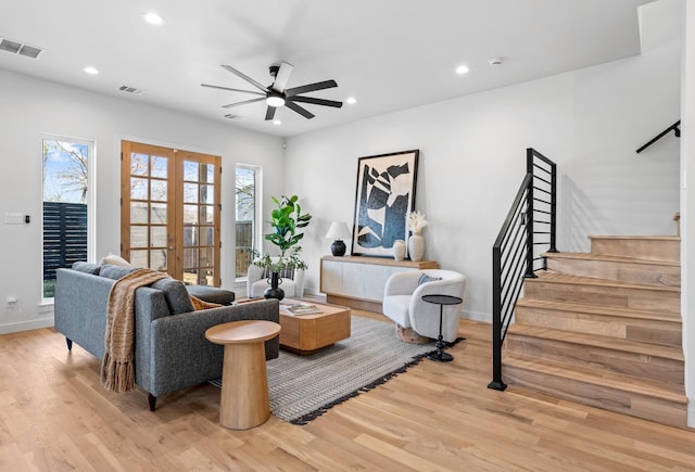 living area featuring stairs, visible vents, wood finished floors, and french doors