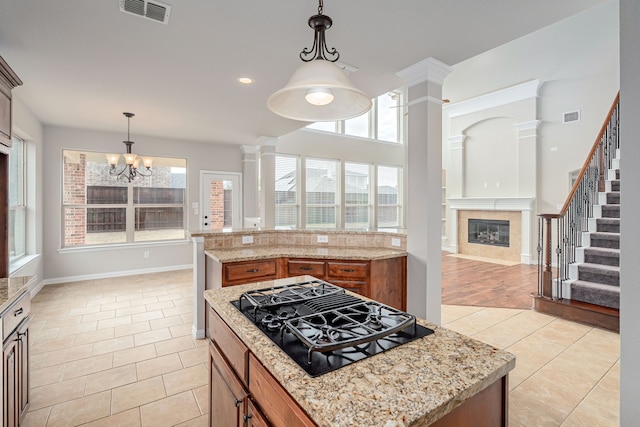 kitchen with brown cabinetry, visible vents, black gas stovetop, and light tile patterned flooring