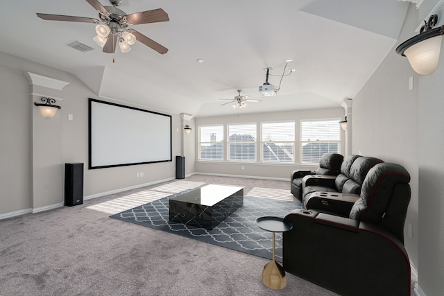 carpeted cinema room with vaulted ceiling, ceiling fan, visible vents, and baseboards