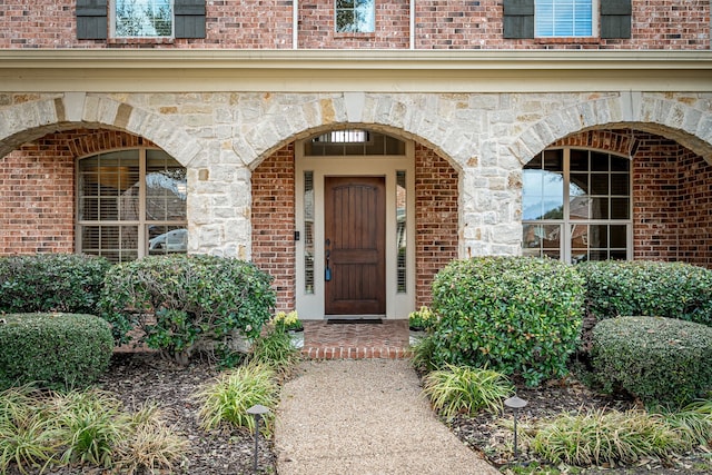 entrance to property with stone siding and brick siding