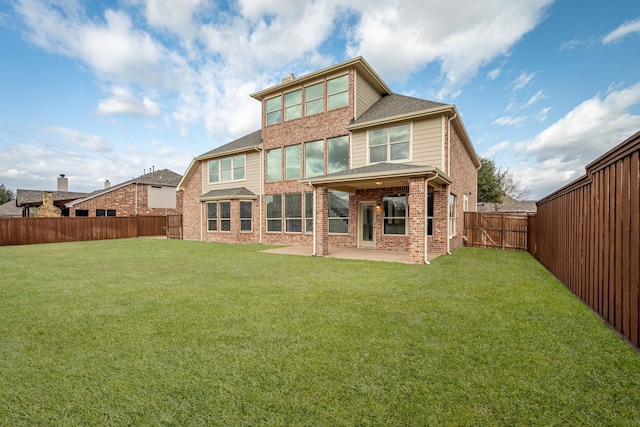 rear view of house featuring brick siding, a yard, a patio, a gate, and a fenced backyard