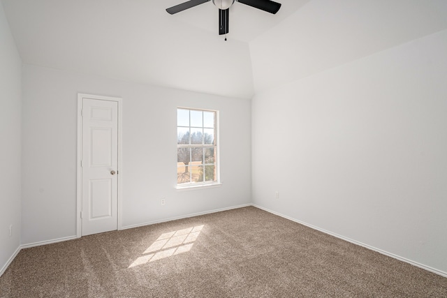 carpeted empty room featuring vaulted ceiling, ceiling fan, and baseboards