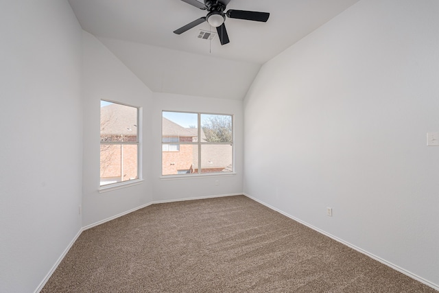 carpeted spare room featuring lofted ceiling, ceiling fan, visible vents, and baseboards