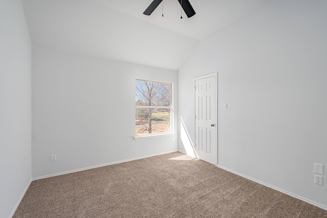 empty room featuring ceiling fan, baseboards, vaulted ceiling, and carpet flooring