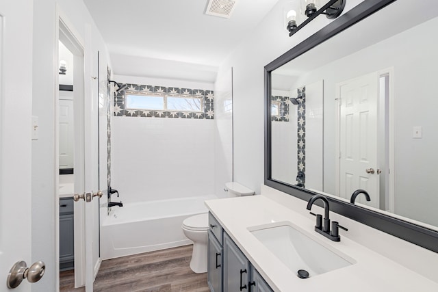 bathroom with visible vents, toilet, washtub / shower combination, vanity, and wood finished floors