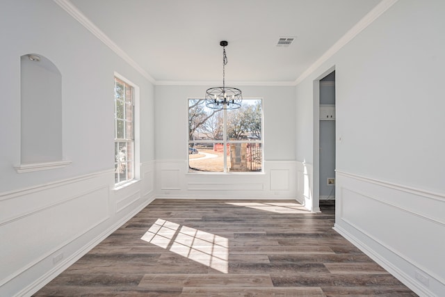 unfurnished dining area featuring a healthy amount of sunlight, an inviting chandelier, dark wood-style floors, and visible vents