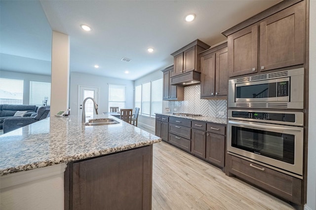 4130 Lagoon Pl, Royse City, TX 75189 - kitchen featuring appliances with stainless steel finishes, a sink, light wood-type flooring, light stone countertops, and recessed lighting